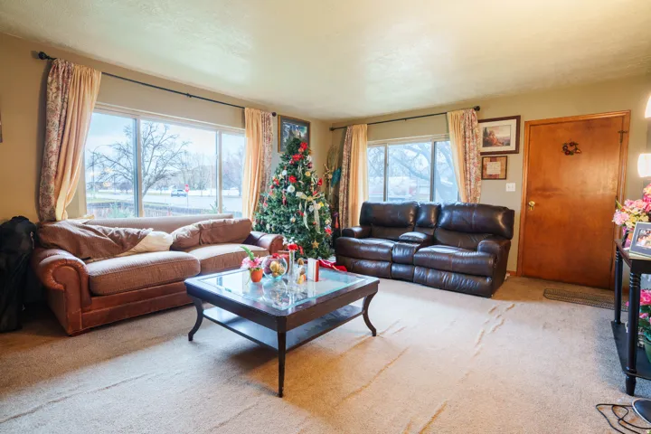 Living area featuring expansive front-facing windows with curtain rods