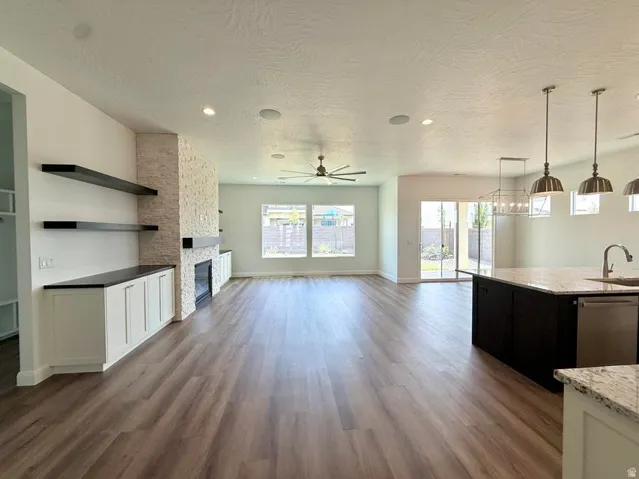 Open-concept living area with wood-finish flooring, recessed lighting, and a ceiling fan
