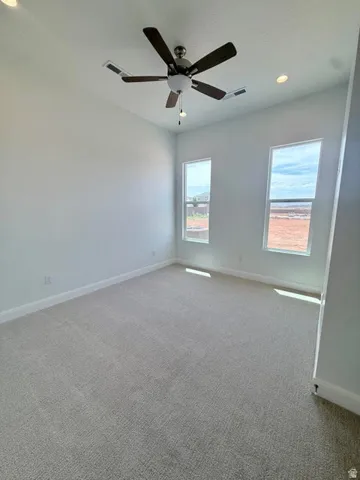 Spacious room featuring light-colored carpeting and white baseboards