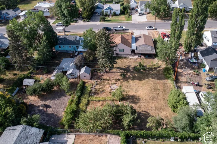Expansive undeveloped lot with perimeter landscaping, featuring established trees and shrubs
