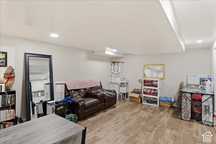 Spacious room featuring wood-finish flooring, recessed lighting, and light-toned walls