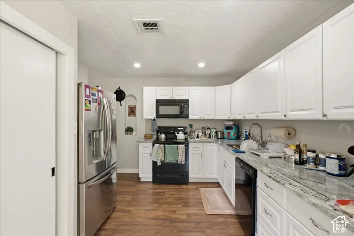 Kitchen featuring wood-finish flooring, white cabinetry, and light-colored countertops