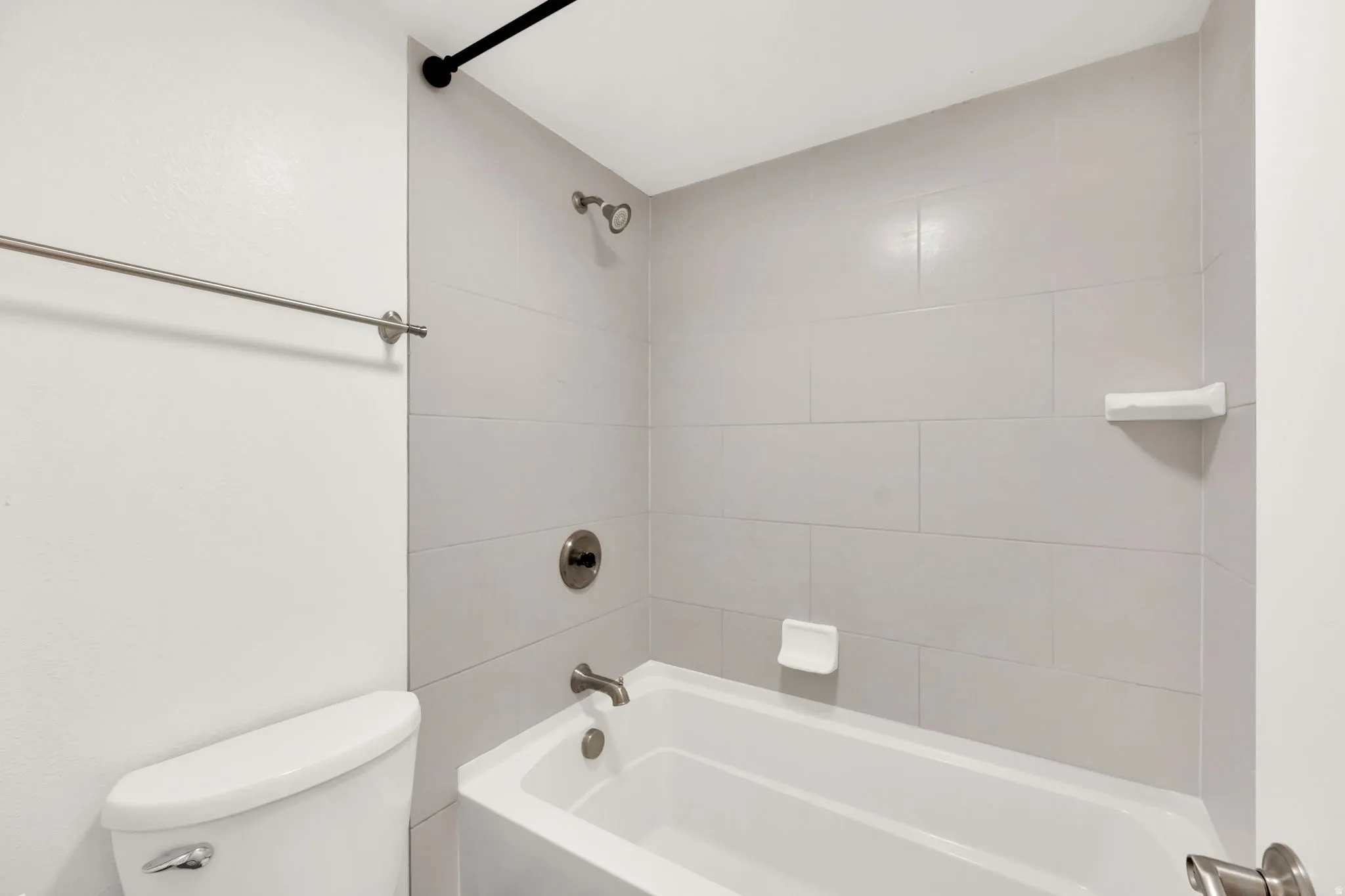 Bathtub and shower combination featuring large format tile surround