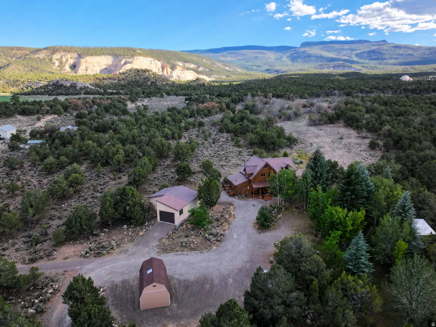 Expansive property featuring a log-style residence, detached garage, and an additional shed