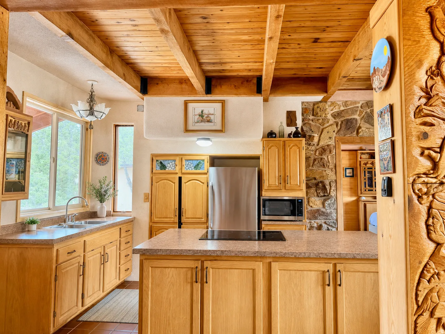 Kitchen featuring light wood cabinetry, stone-finish countertops, and a wood-beamed ceiling