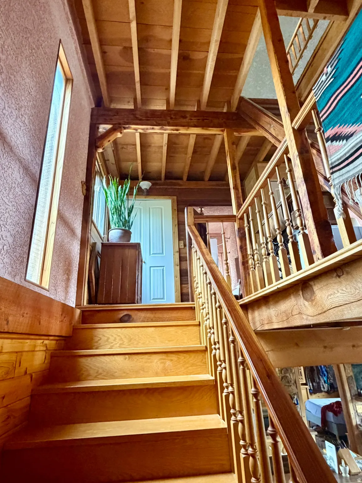 Warm wood-finish staircase with turned balusters and railing