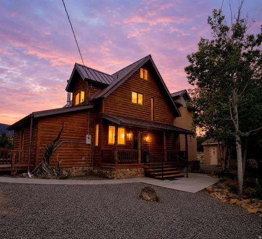 Log cabin exterior with a metal roof and stone foundation