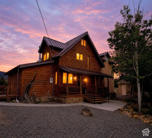 Log cabin exterior with a metal roof and stone foundation