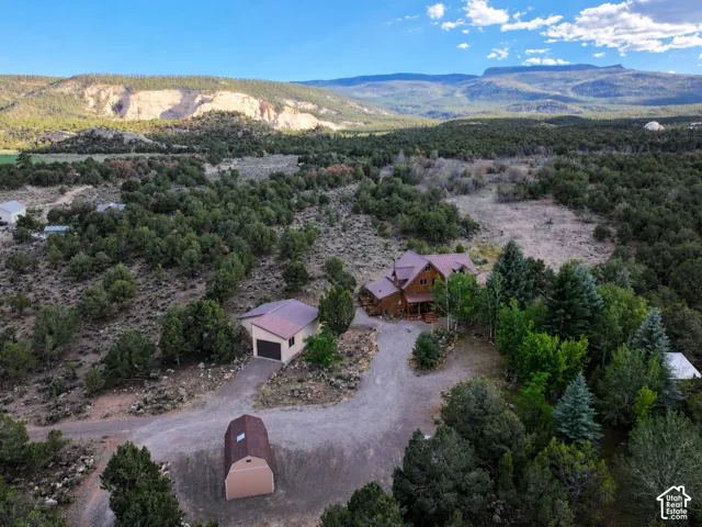 Expansive property featuring a log-style residence, detached garage, and an additional shed