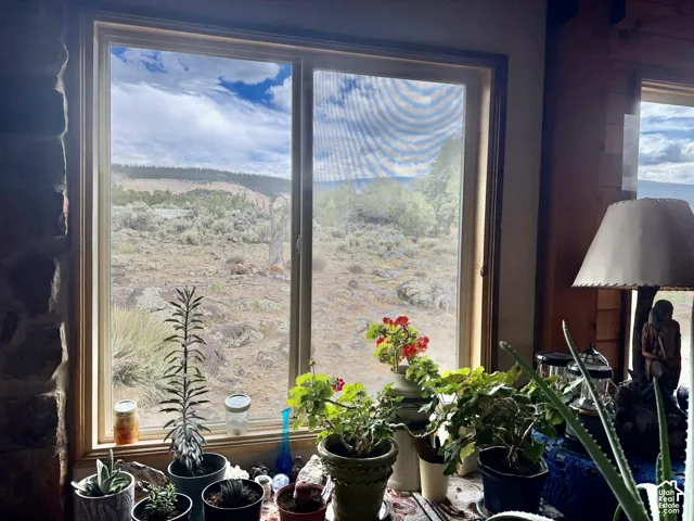 Expansive window framing a desert landscape with distant hills and a partially cloudy sky