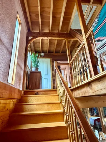 Warm wood-finish staircase with turned balusters and railing