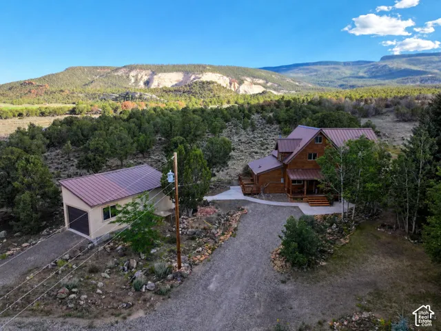 Wood-sided home with a multi-level roofline, surrounded by abundant natural landscaping