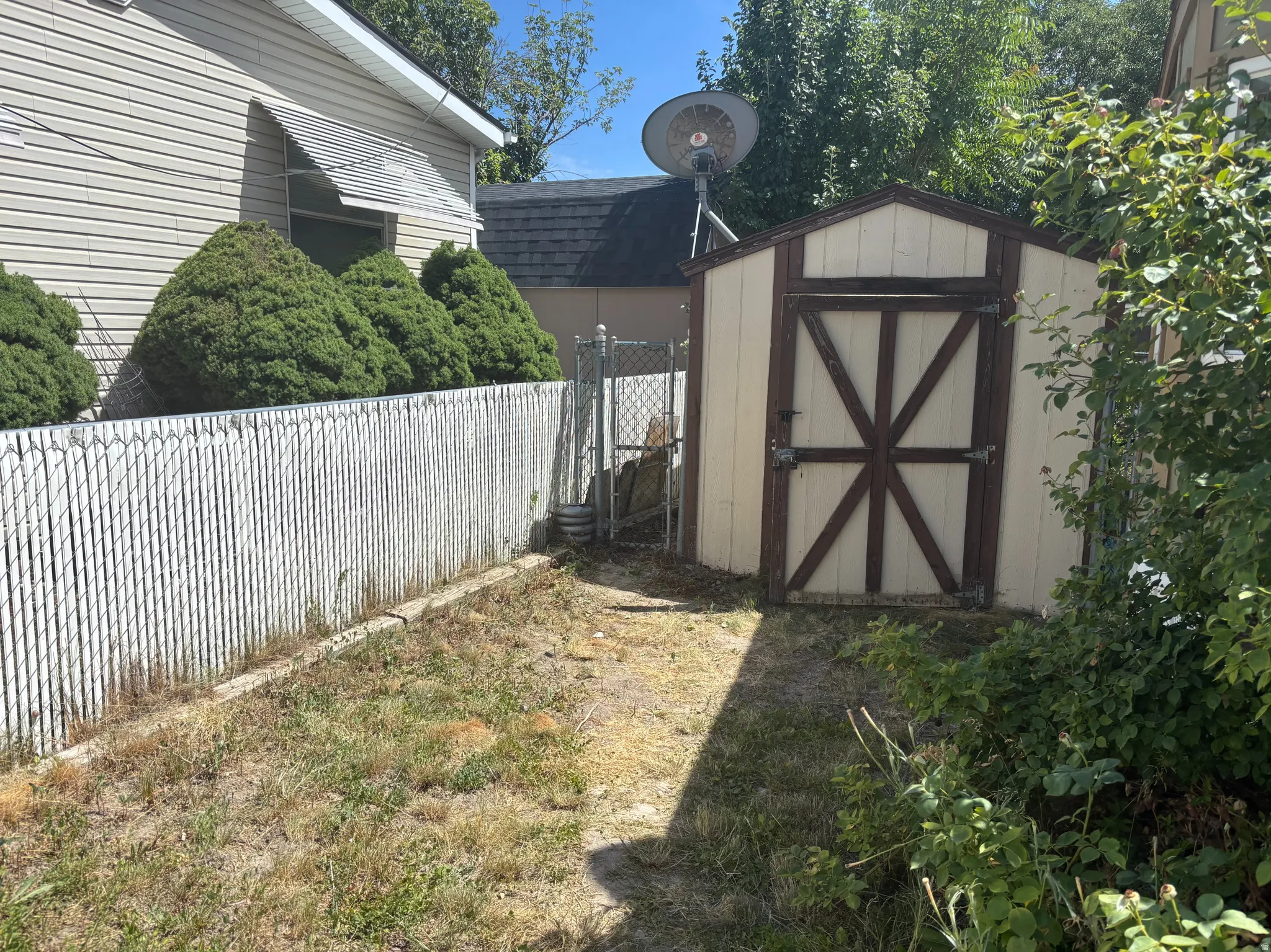 Detached storage shed with a gable roof and paneled double doors
