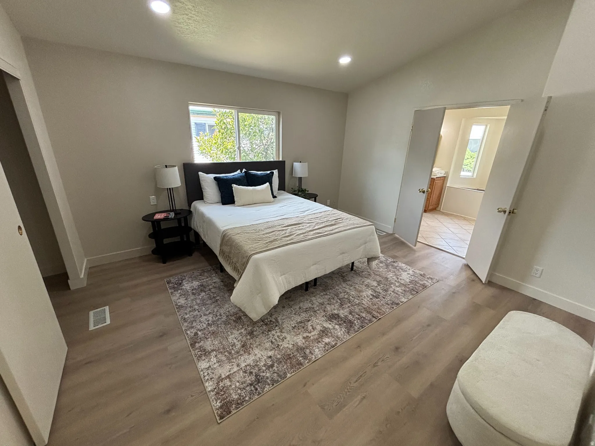Spacious room featuring wood-finish flooring, recessed lighting, and a window with exterior views