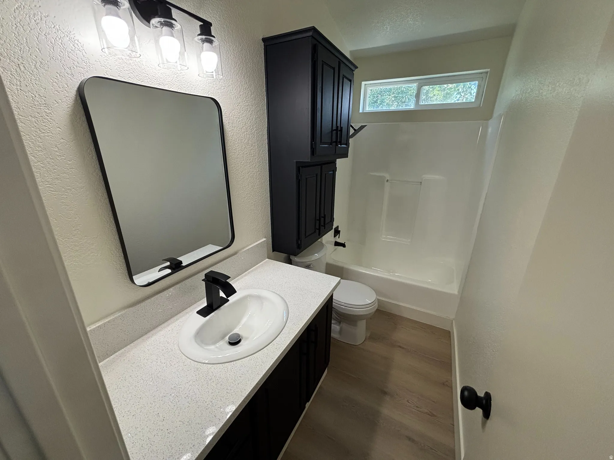 Bathroom featuring a white vanity with an undermount sink, black cabinetry, a black framed mirror, and a black faucet