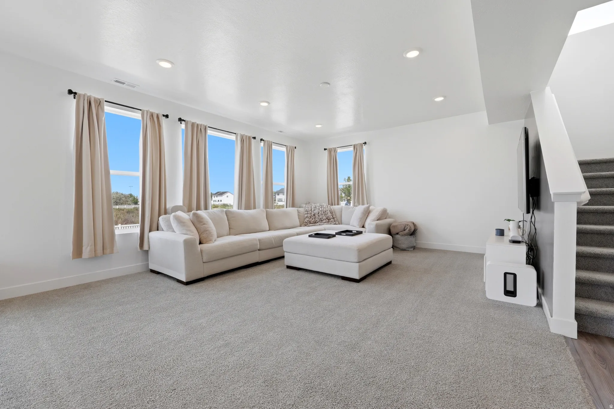 Bright living space with light-toned carpet flooring