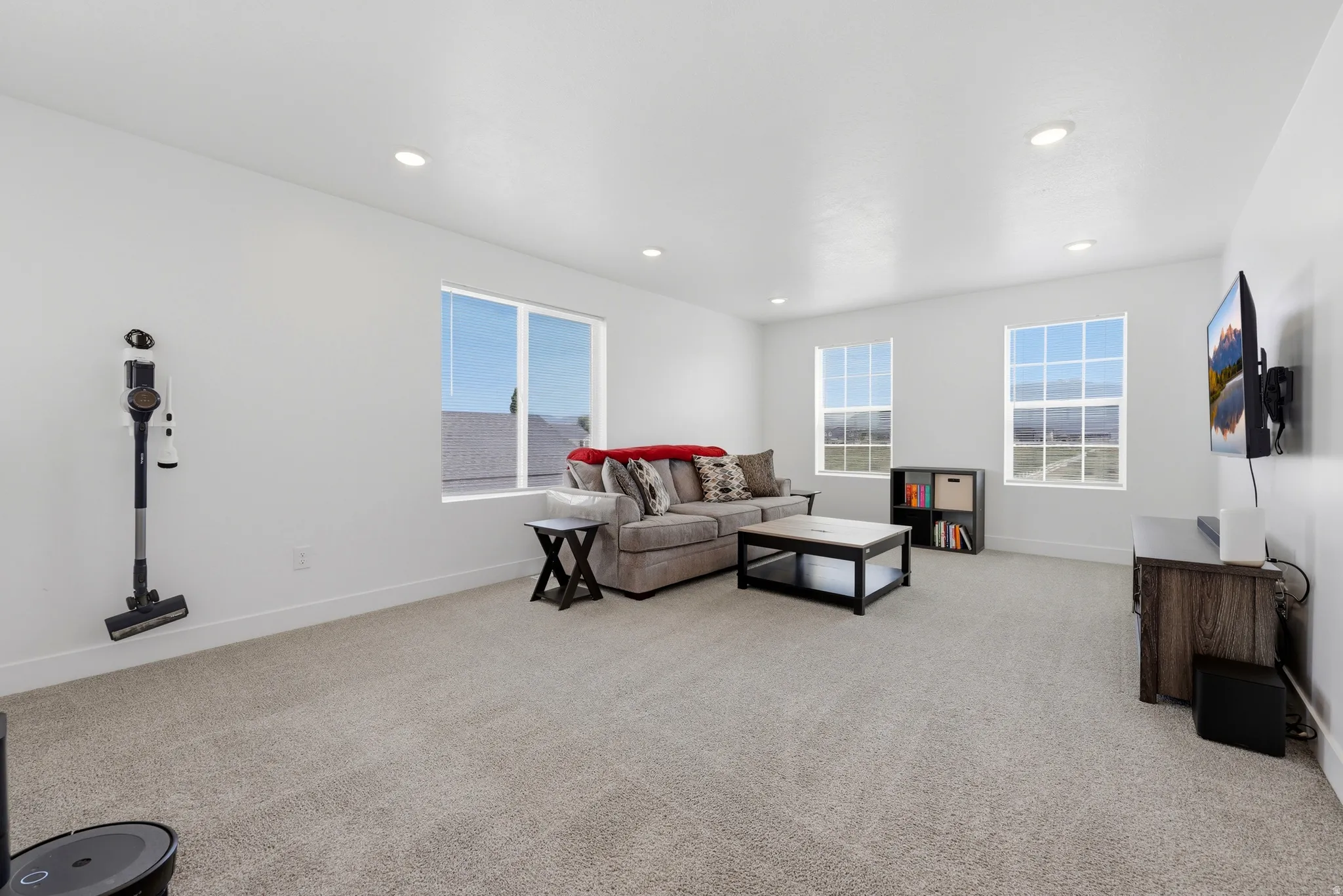 Spacious bonus room featuring light-toned carpeting, recessed lighting, and multiple windows