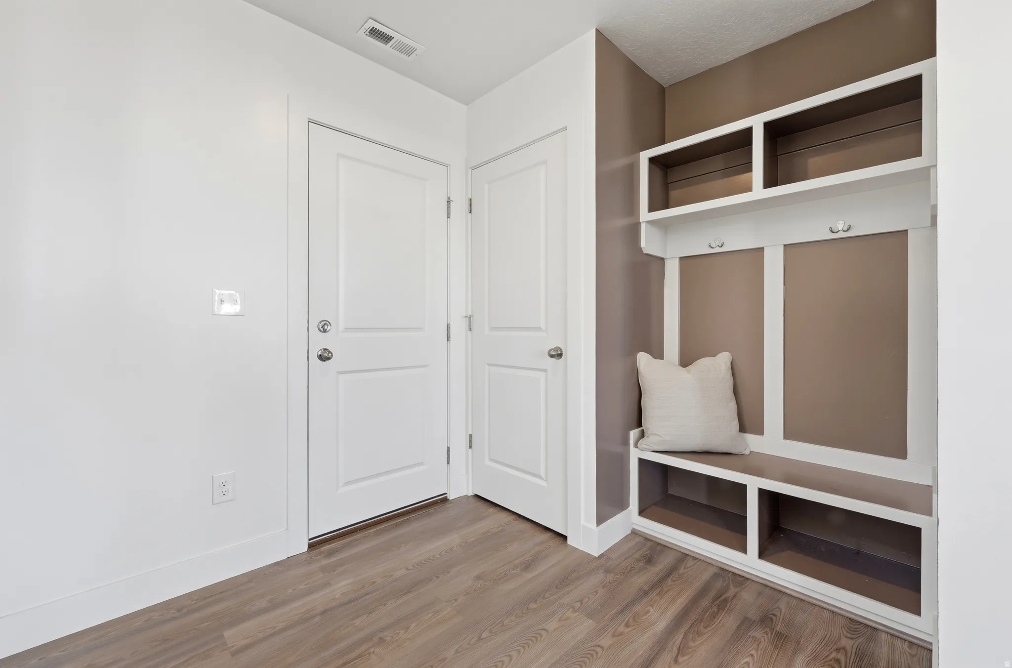 Built-in mudroom bench with cubby storage and upper shelving