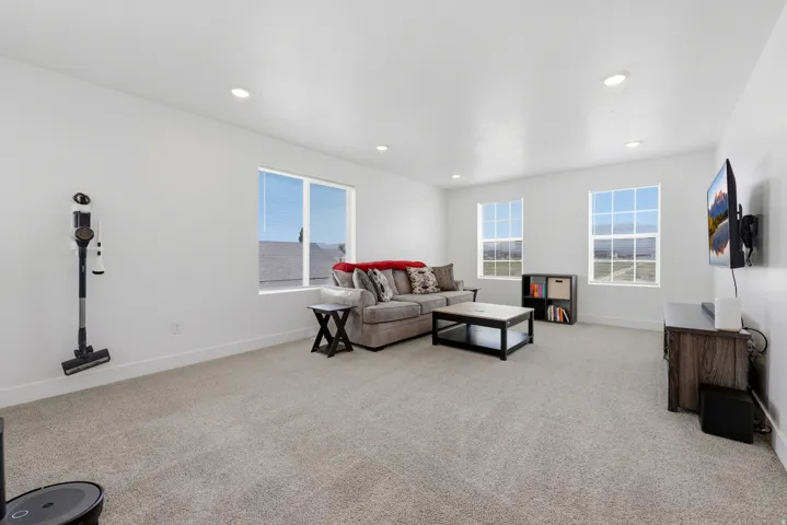 Spacious bonus room featuring light-toned carpeting, recessed lighting, and multiple windows