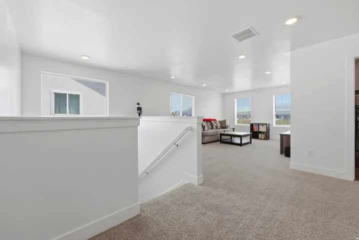 Spacious carpeted landing with a white painted railing