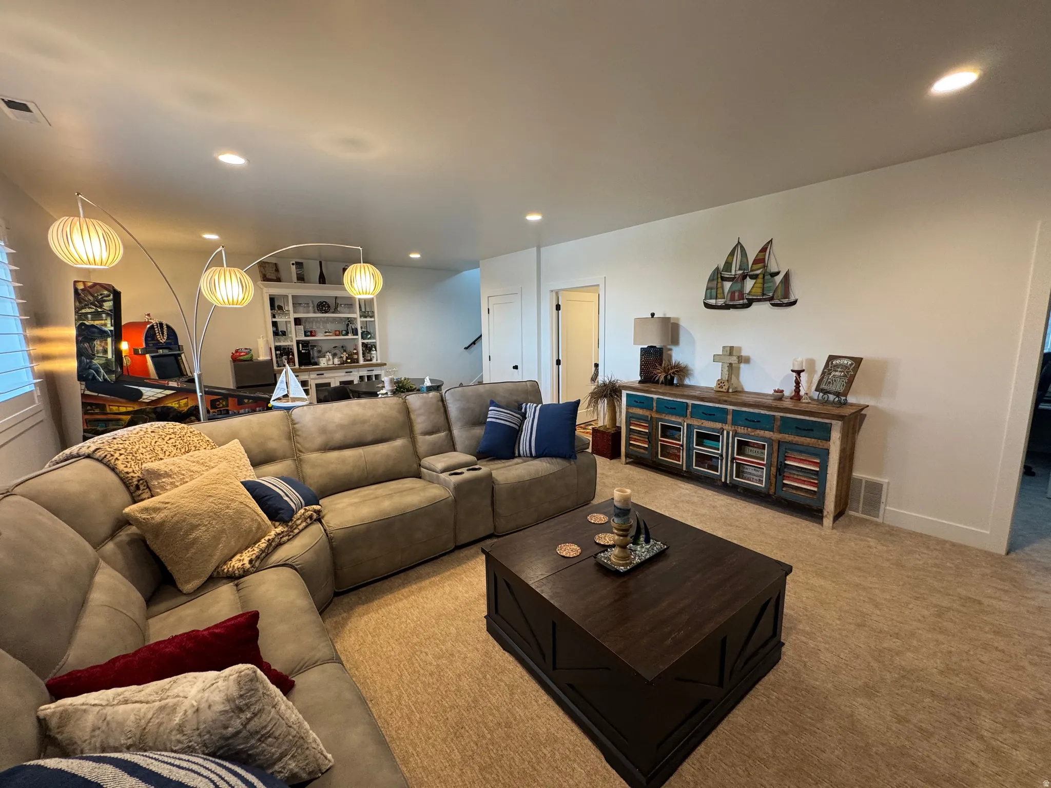 Spacious living area featuring neutral carpeting and recessed lighting