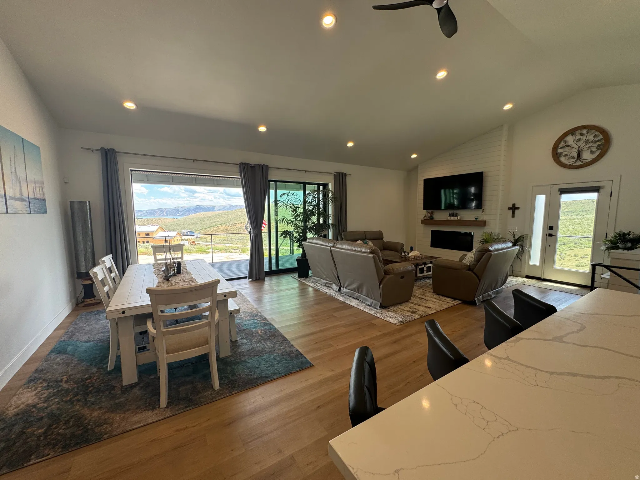 Open-concept living space featuring wood-finish flooring, recessed lighting, and a vaulted ceiling