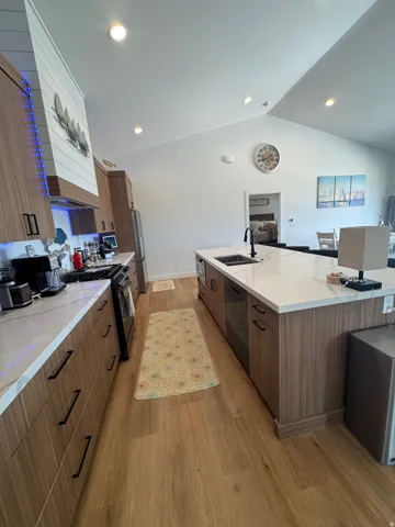 Contemporary kitchen featuring wood-finish cabinetry, white countertops, and wood-finish flooring