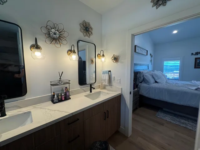 Dual vanity with a stone-finish countertop, undermount sinks, and matte black fixtures