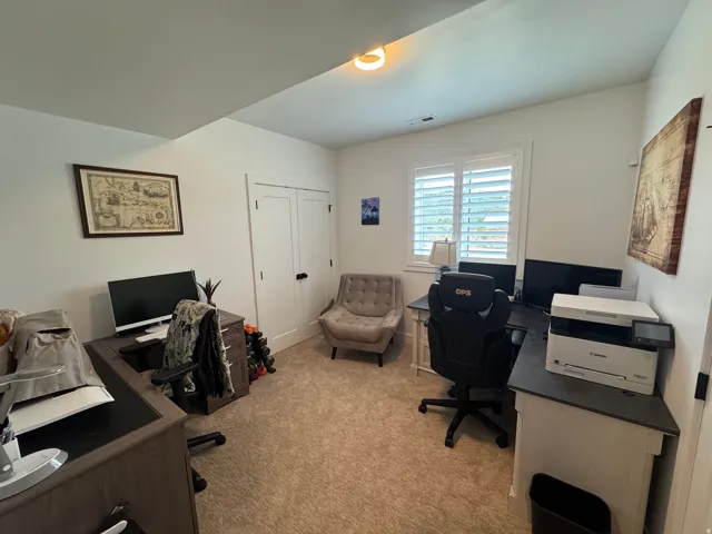 Neutral-toned carpeting and white walls define this versatile room