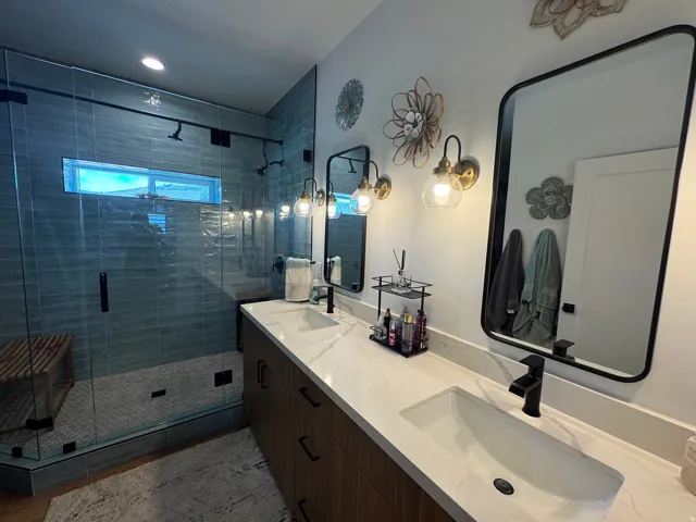 Double vanity with undermount sinks, white countertops, and wood-finish cabinetry