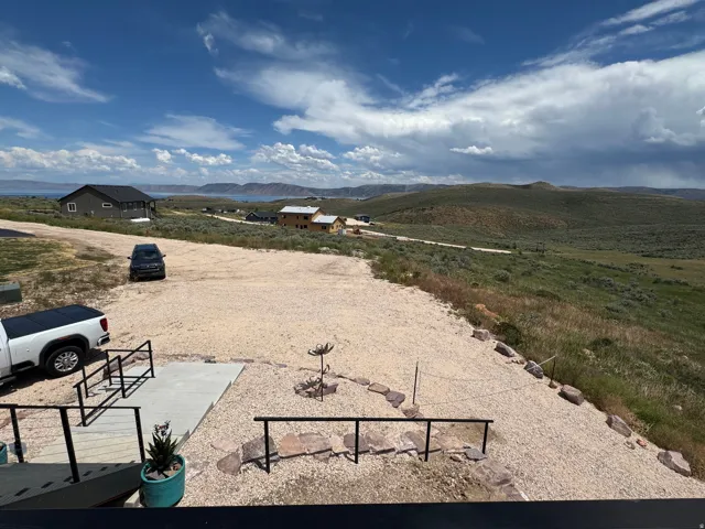Expansive gravel parking area with a concrete walkway leading to the entrance
