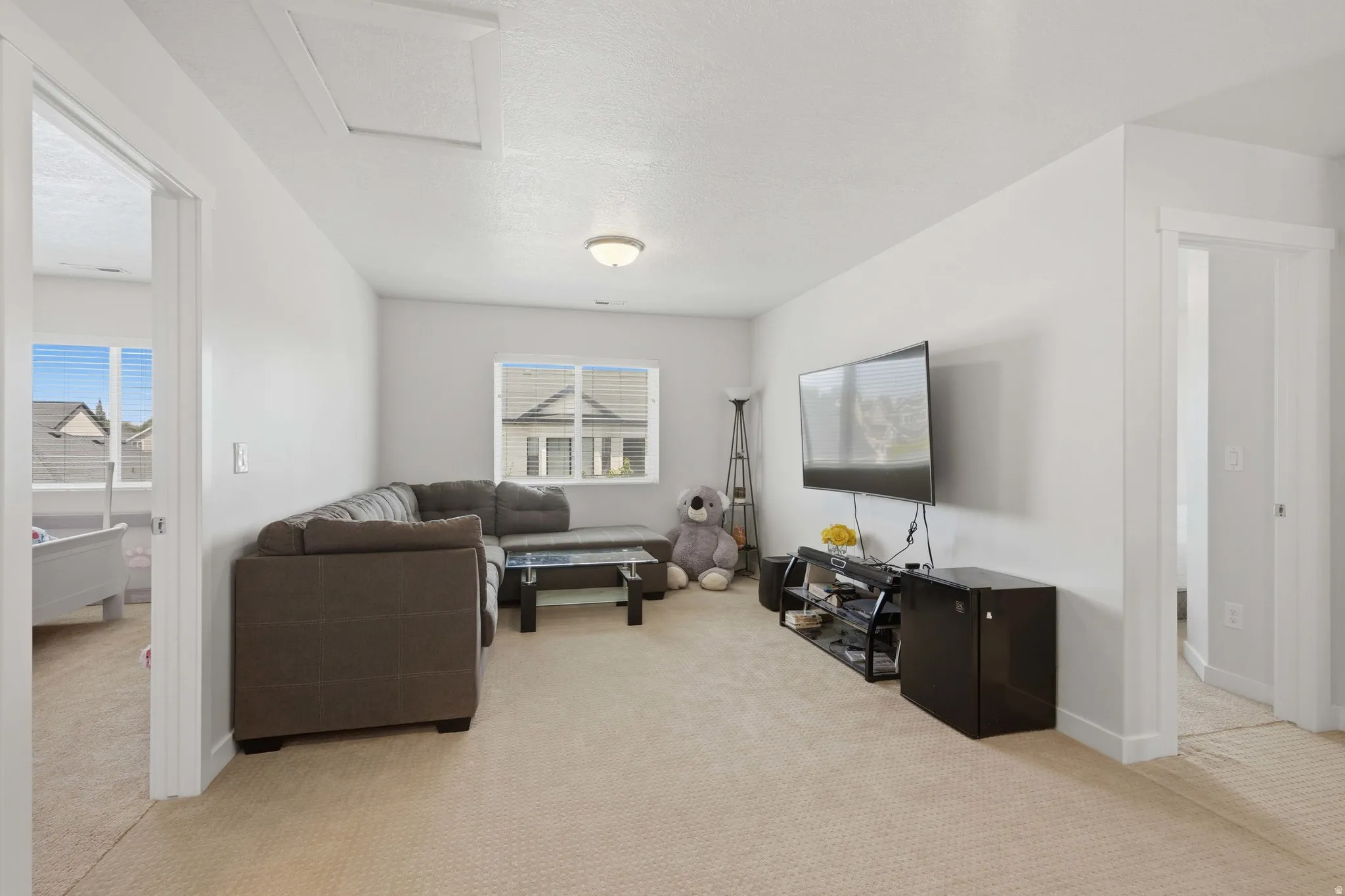 Carpeted bonus room featuring neutral wall paint, white trim, and a ceiling-mounted light fixture