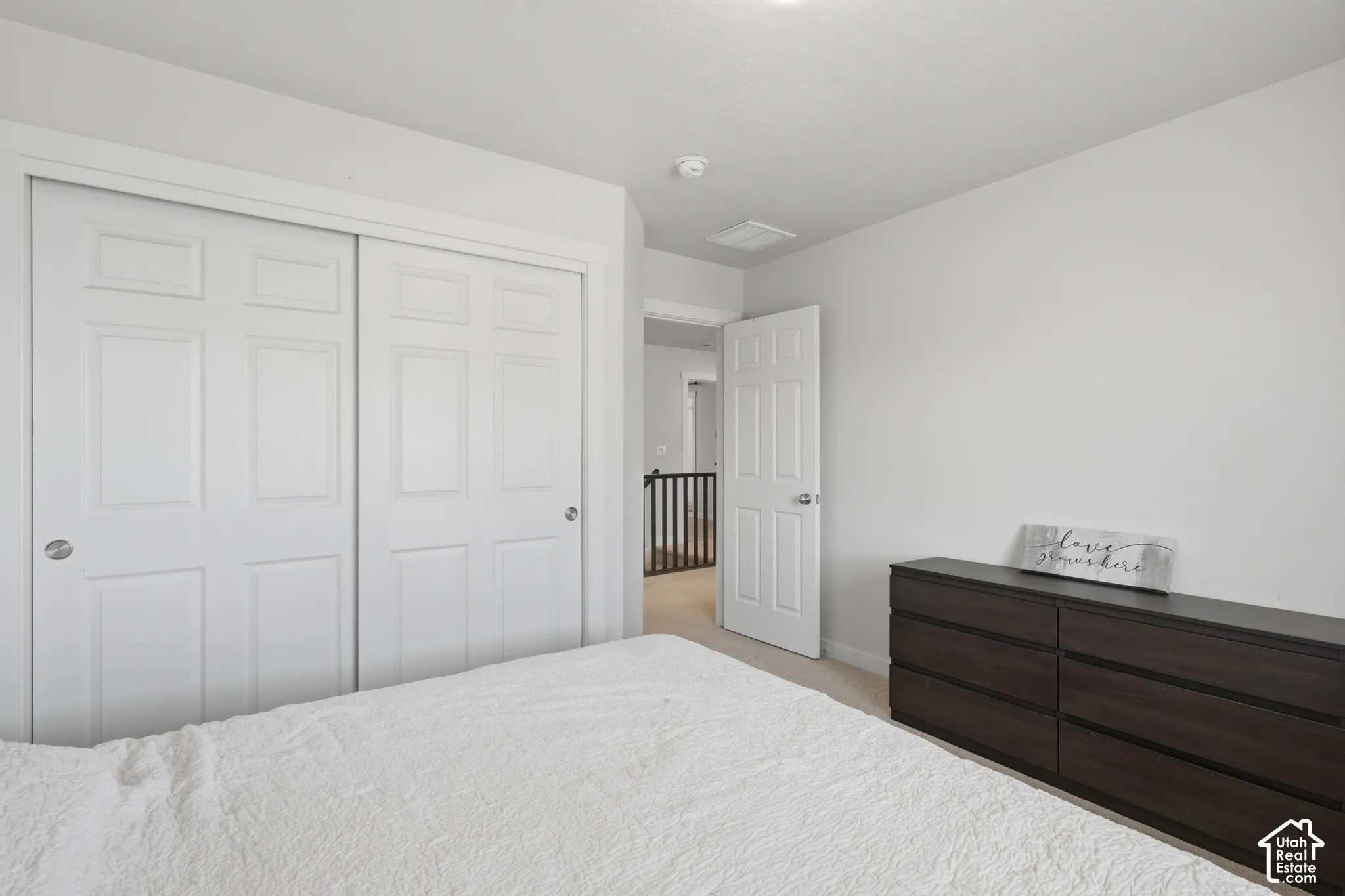 Spacious bedroom featuring dual sliding closet doors with six-panel styling, light neutral wall tones, and recessed ceiling lighting