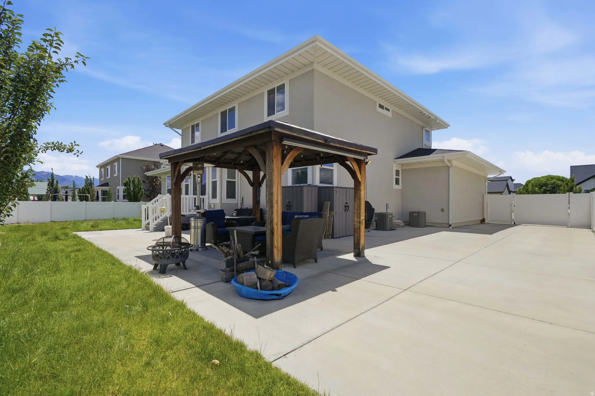 Spacious concrete patio featuring a wood pergola and a substantial grass area