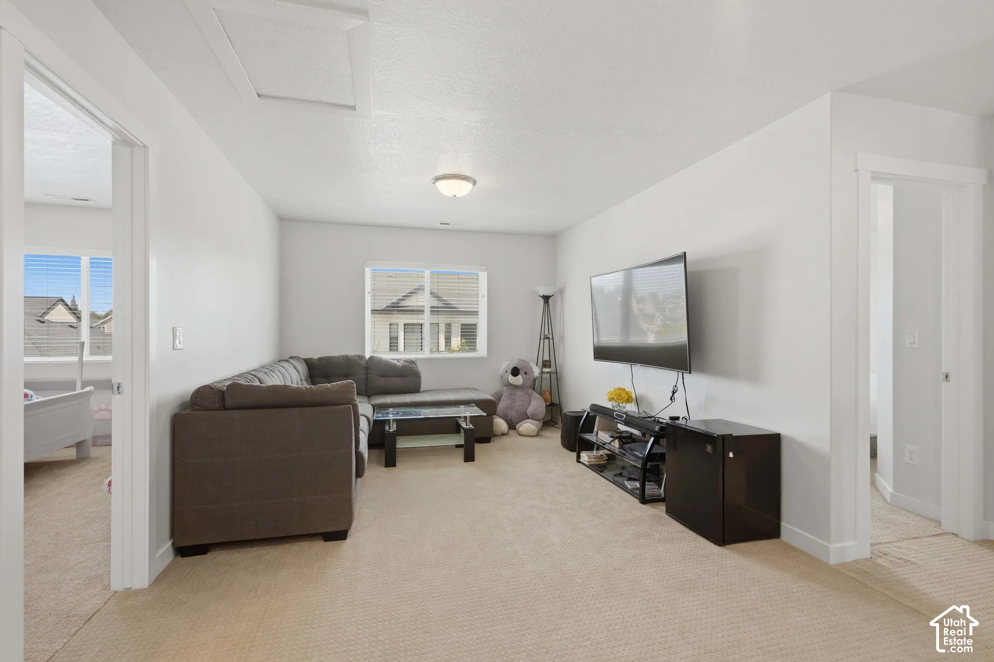 Carpeted bonus room featuring neutral wall paint, white trim, and a ceiling-mounted light fixture