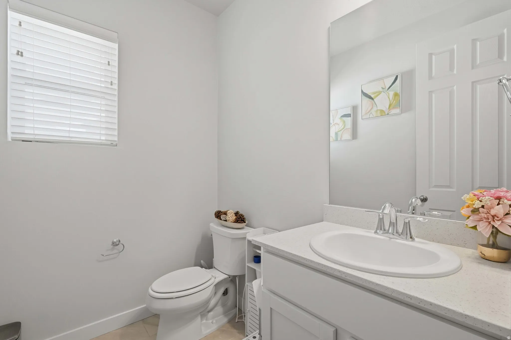 Bathroom featuring a white vanity with an integrated sink, polished chrome faucet, and a large wall-mounted mirror