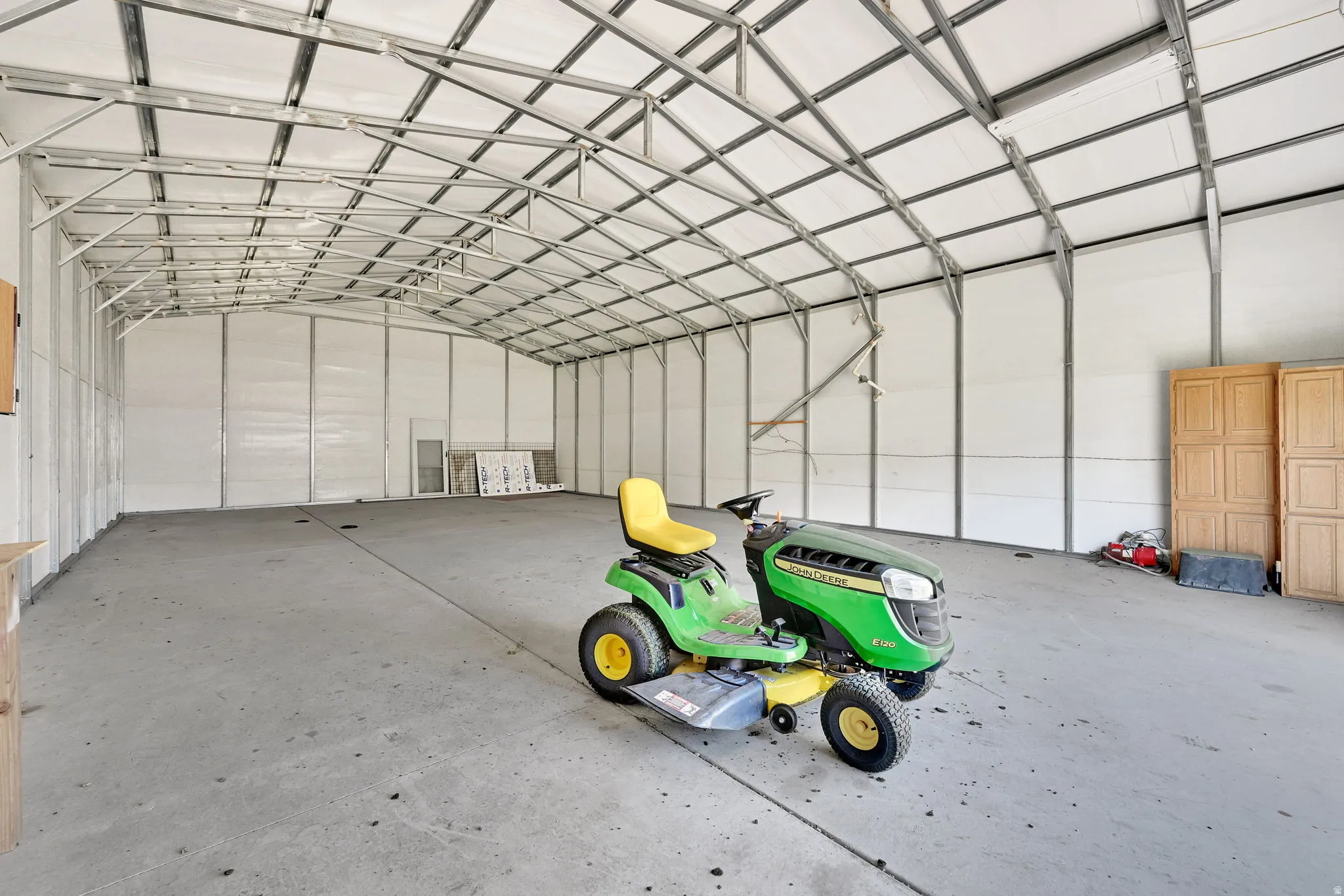 Spacious utility building featuring a high arched ceiling with exposed metal framework