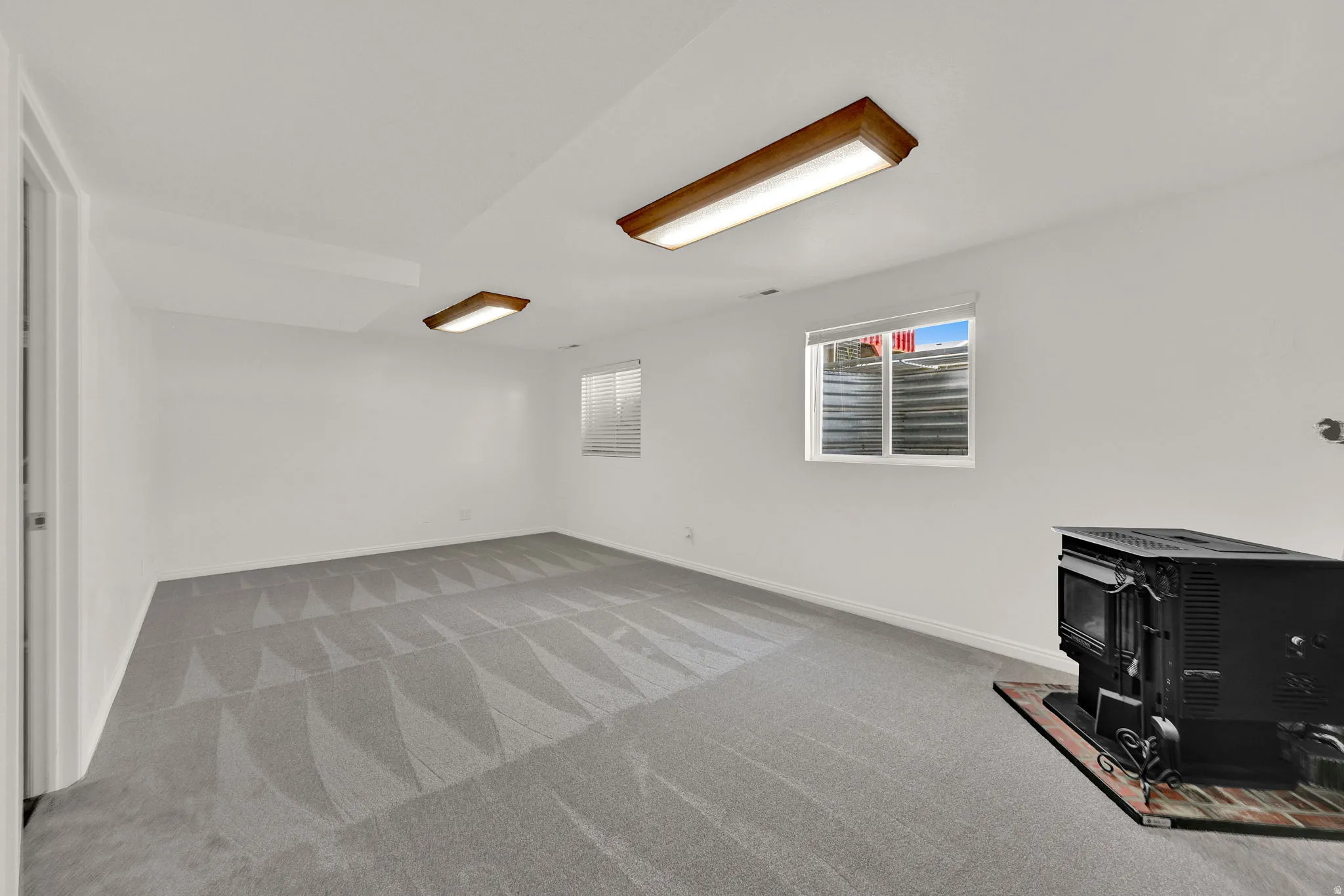 Spacious basement family room with light gray patterned carpeting