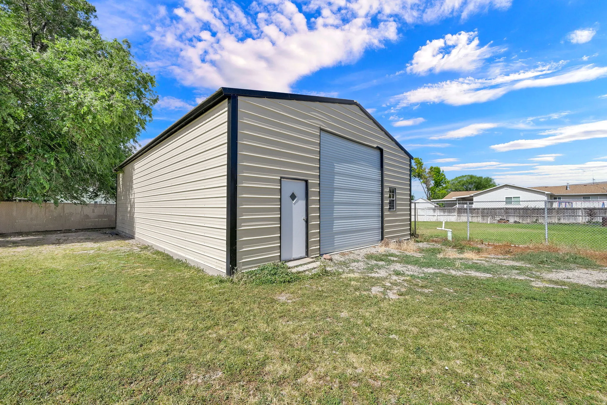 Detached metal building featuring a roll-up door and a separate entry door