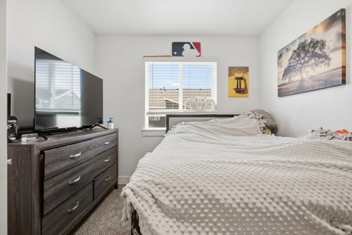 Interior room featuring a window with horizontal blinds, light gray wall paint, and carpeted flooring