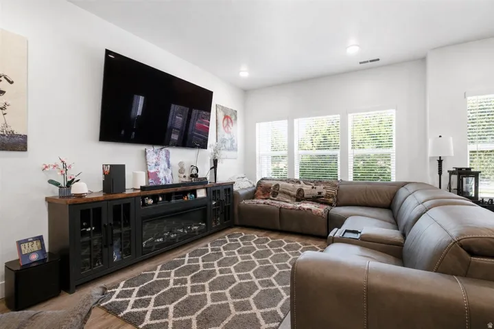 Living area with light wood-finish flooring and a corner window arrangement