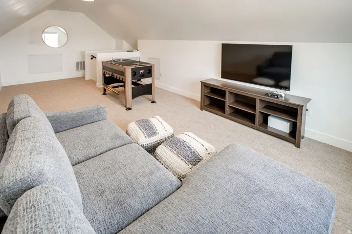 Expansive bonus room featuring sloped ceilings, recessed lighting, and neutral carpeting