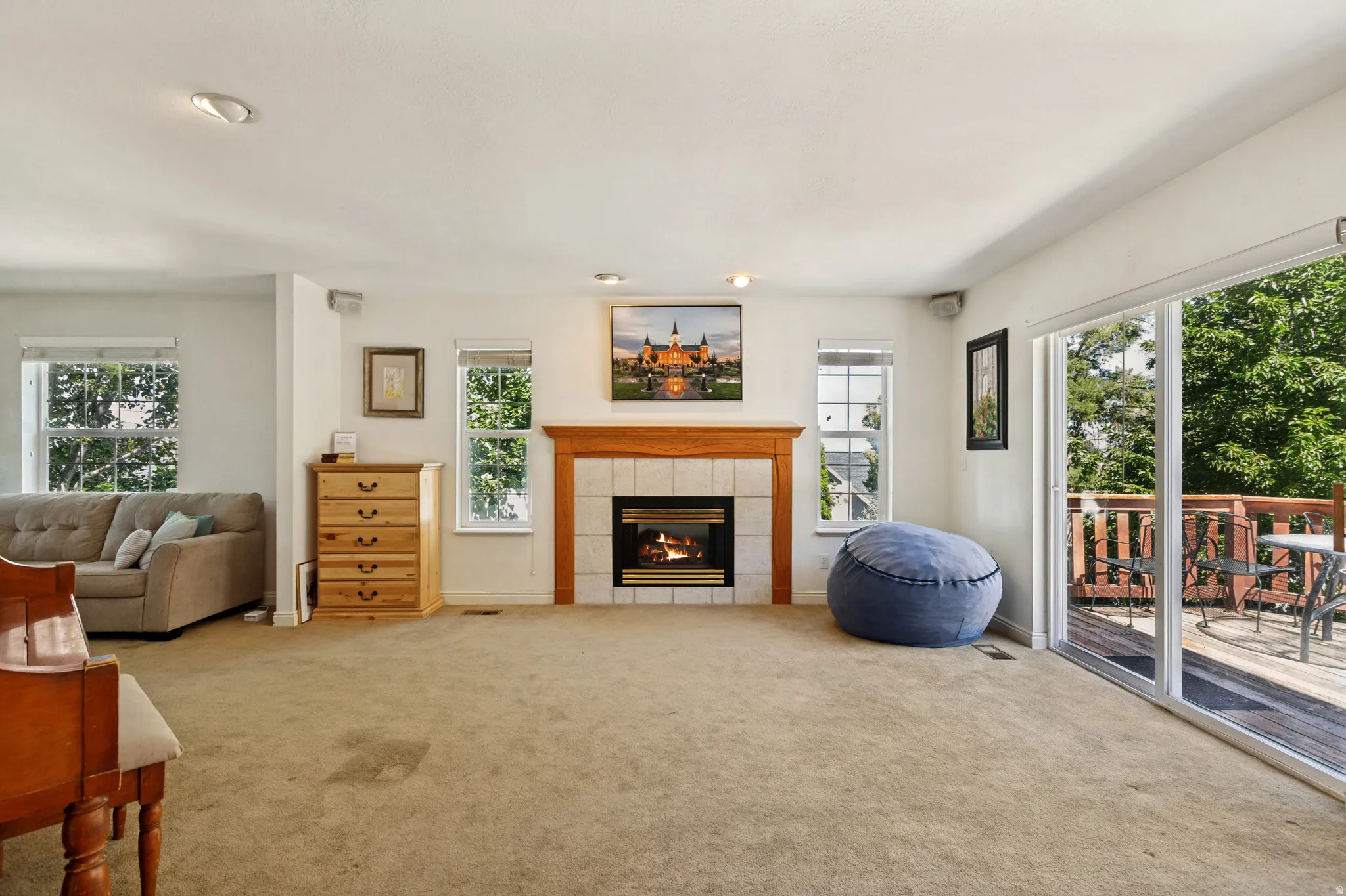 Spacious room featuring a central fireplace with a wood mantle and tile surround
