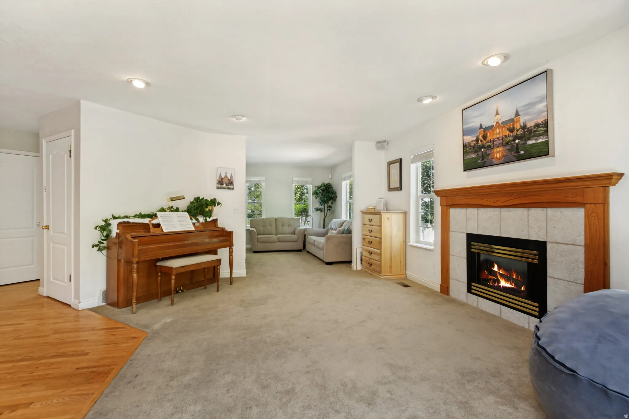 Spacious living area featuring a central fireplace with wood mantel and tile surround