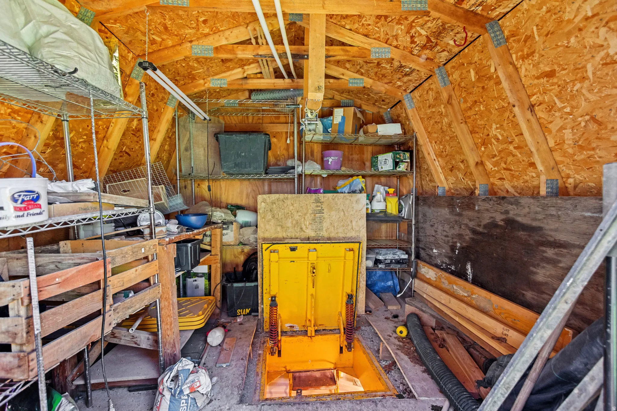 Attic space featuring exposed wood framing and particle board walls