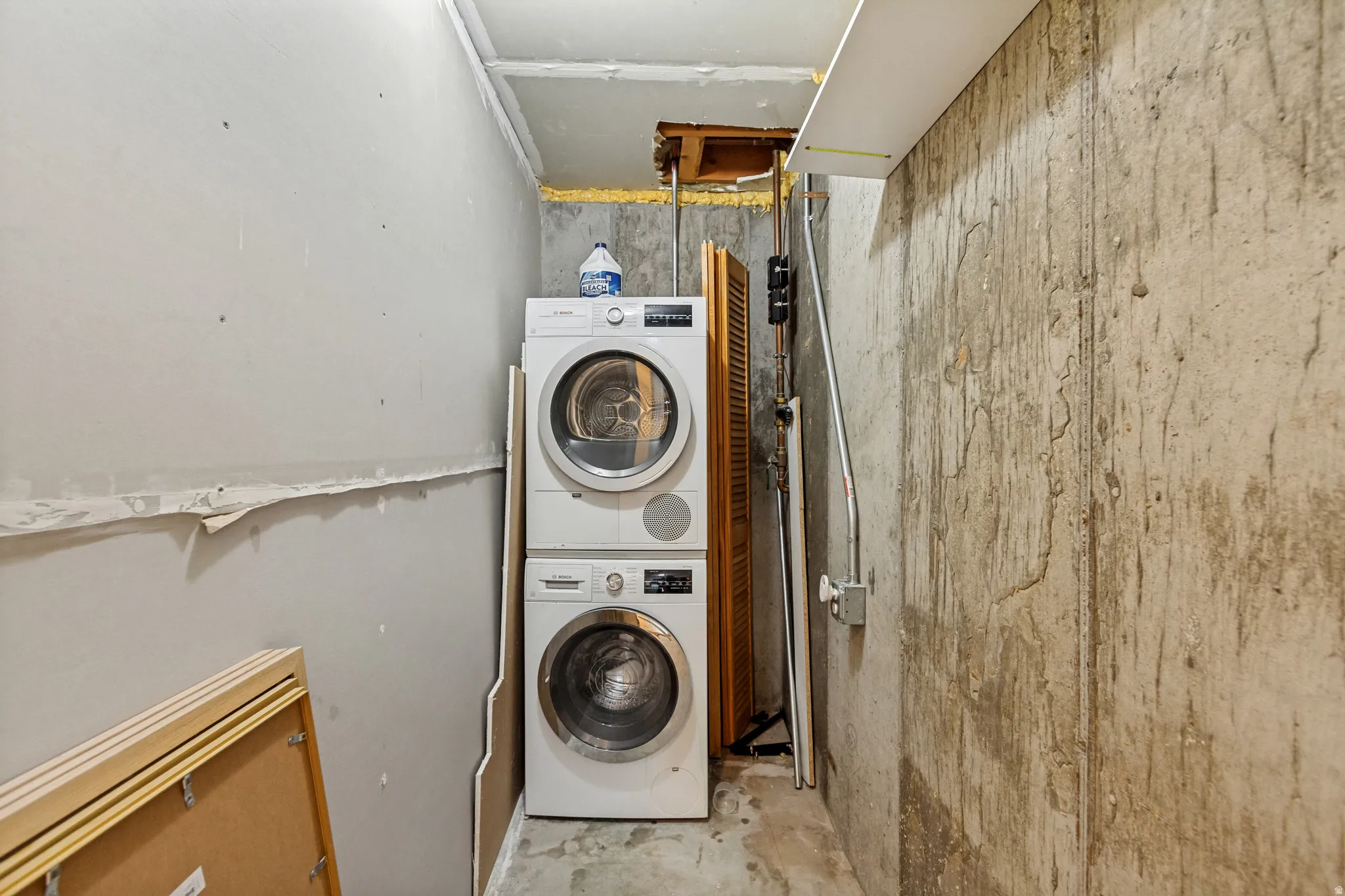Dedicated laundry area featuring a stacked washer and dryer unit