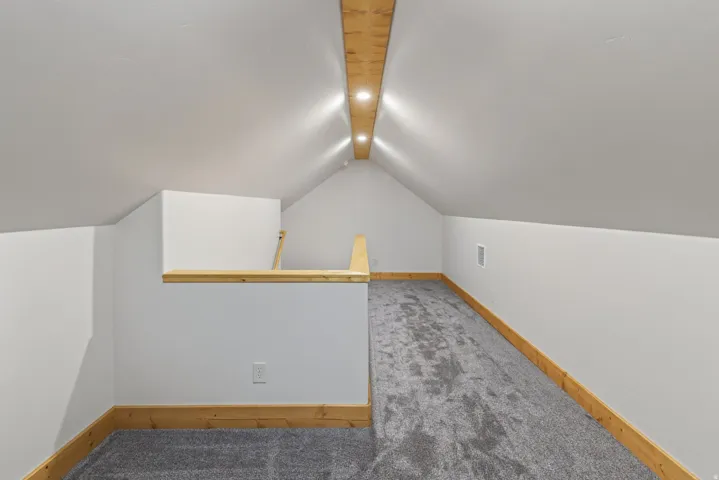 Vaulted ceiling, recessed lighting, wood-finish beam, carpet flooring, and wood-finish trim