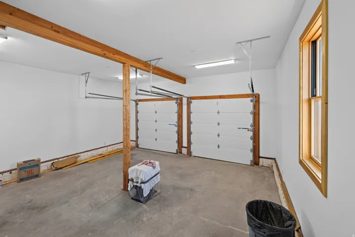 Two white overhead garage doors with wood-finish framing