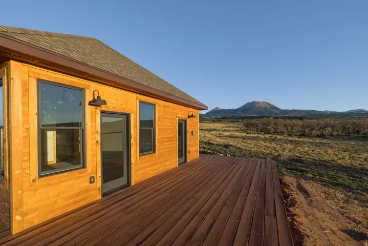 Expansive wood deck with a natural wood-sided exterior and black-framed windows