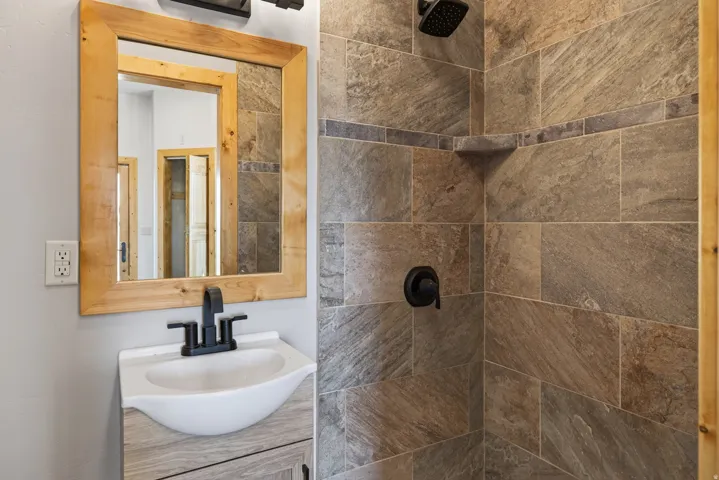 Vanity with wood-finish cabinet, matte black faucet, and rectangular sink